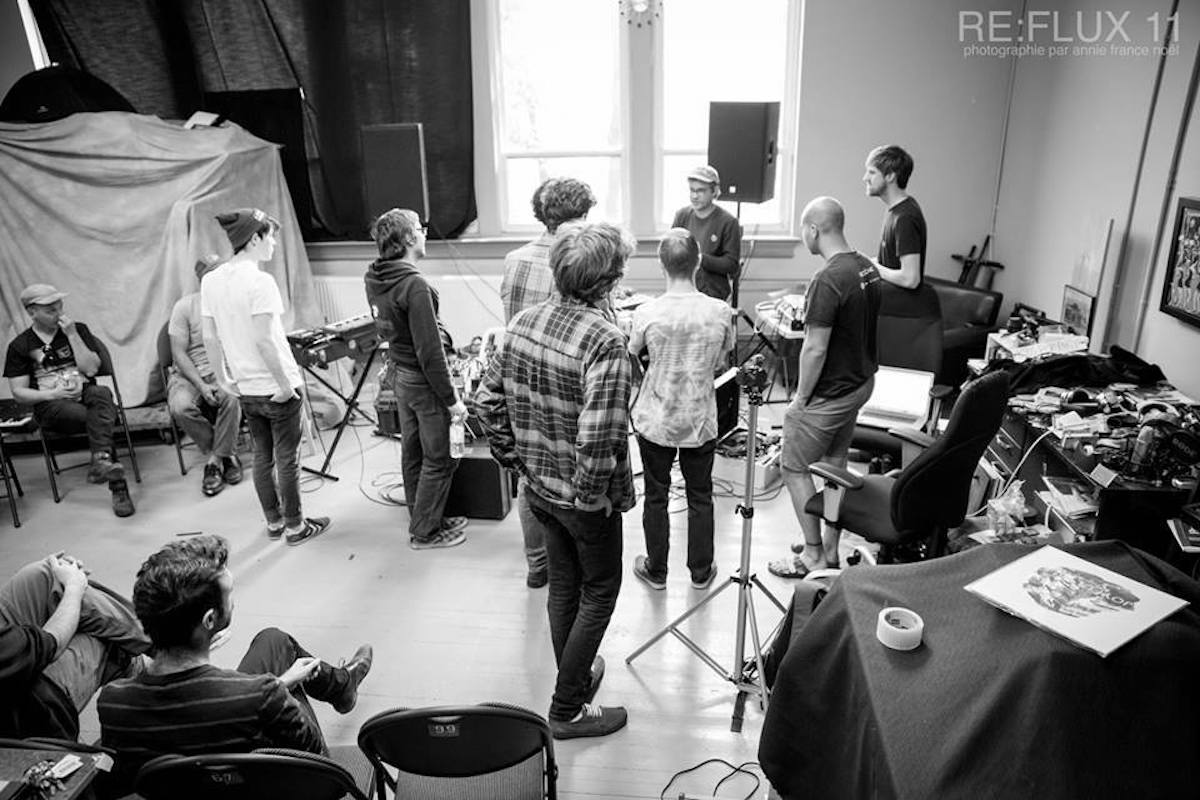 A grey-scale photo of a group of people in a music room